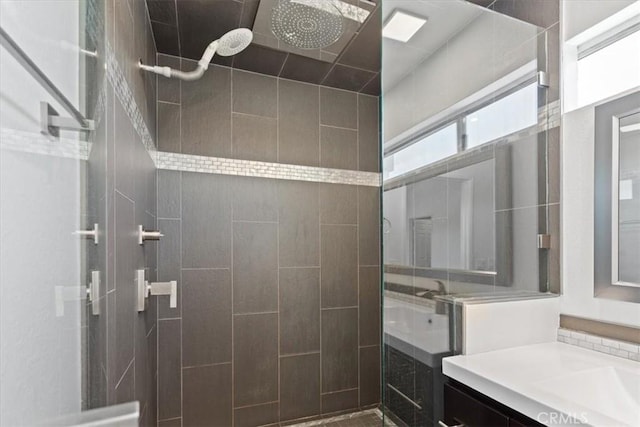 bathroom featuring a tile shower and vanity