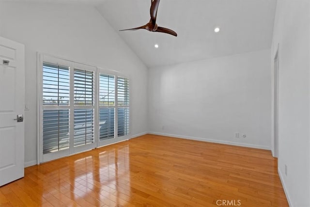 empty room featuring high vaulted ceiling, light wood-style flooring, baseboards, and a ceiling fan