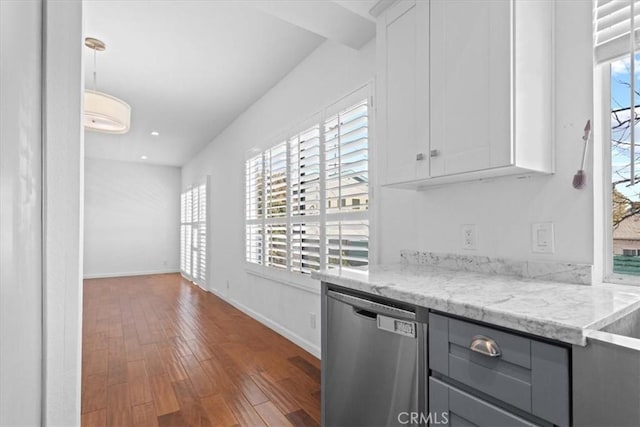 kitchen with light stone counters, dark wood finished floors, white cabinetry, and dishwasher