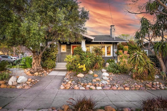 view of property hidden behind natural elements with a chimney