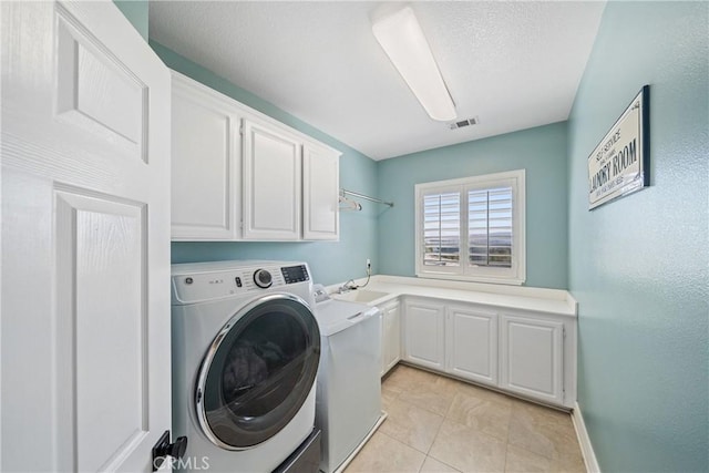 washroom with a sink, washer / dryer, visible vents, and cabinet space