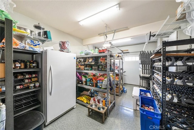 interior space featuring speckled floor and freestanding refrigerator