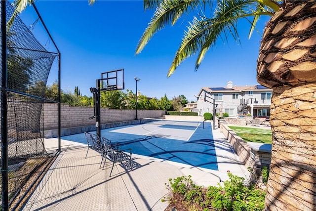 view of basketball court featuring basketball court and fence