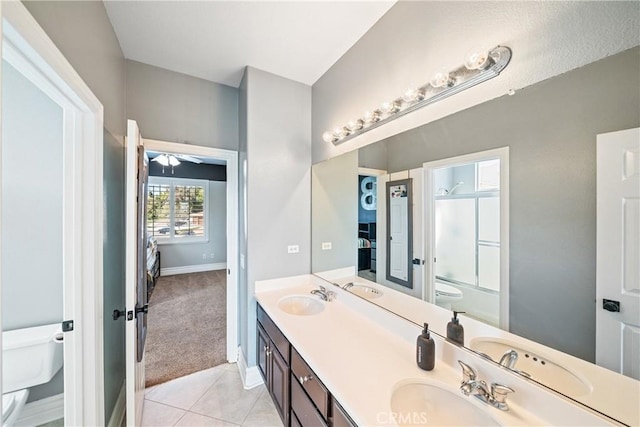 bathroom with bath / shower combo with glass door, a sink, toilet, and double vanity