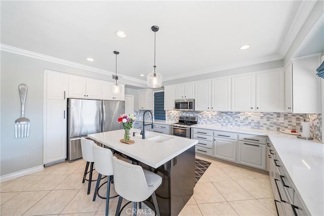 kitchen with stainless steel appliances, an island with sink, and light countertops