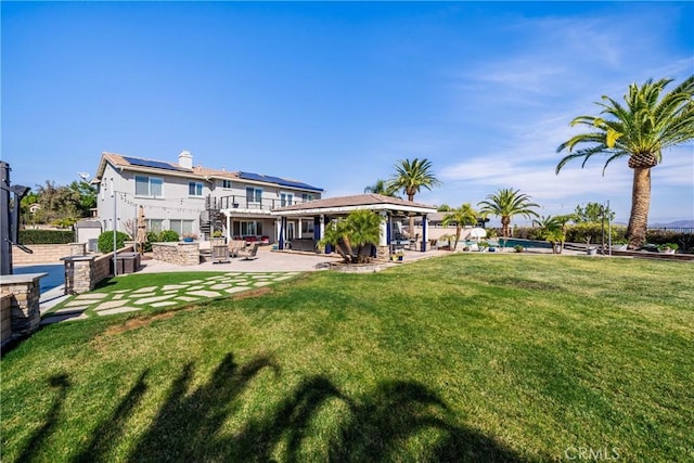 rear view of property with solar panels, a lawn, stairway, a gazebo, and a patio area