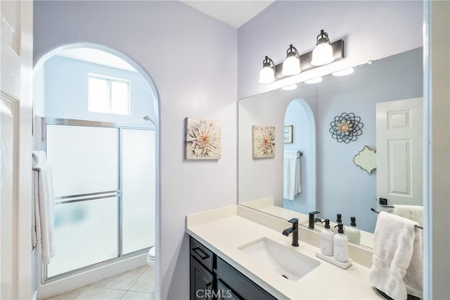 full bath with toilet, a shower stall, tile patterned flooring, and vanity