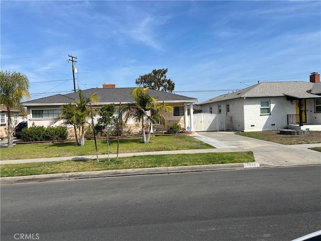 ranch-style house with a chimney, crawl space, a gate, driveway, and a front lawn