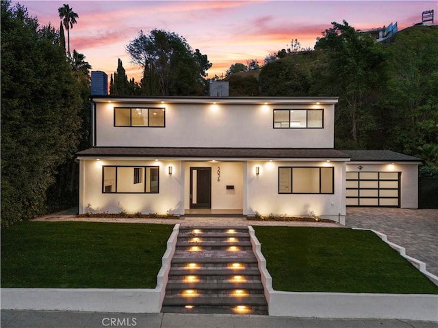 contemporary home with a garage and a lawn