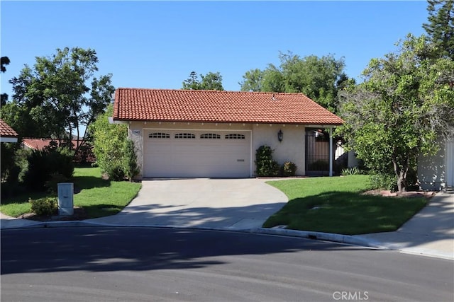 mediterranean / spanish-style home featuring concrete driveway, a front yard, a tile roof, and stucco siding