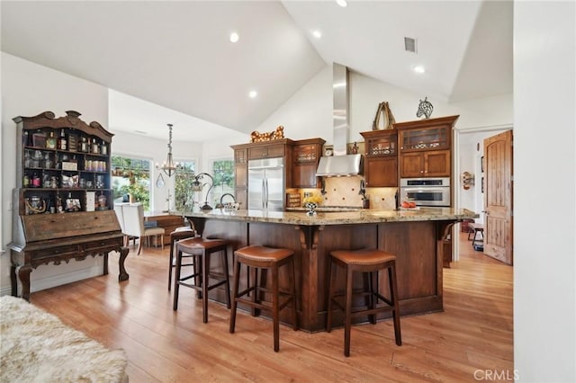 4210 Crestview Dr, Norco, CA 92860 - kitchen with appliances with stainless steel finishes, wall chimney range hood, a chandelier, light wood-type flooring, and high vaulted ceiling