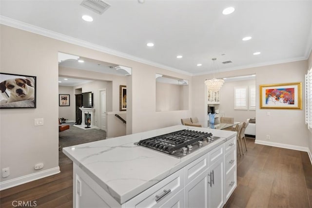 kitchen featuring pendant lighting, visible vents, white cabinetry, open floor plan, and stainless steel gas stovetop