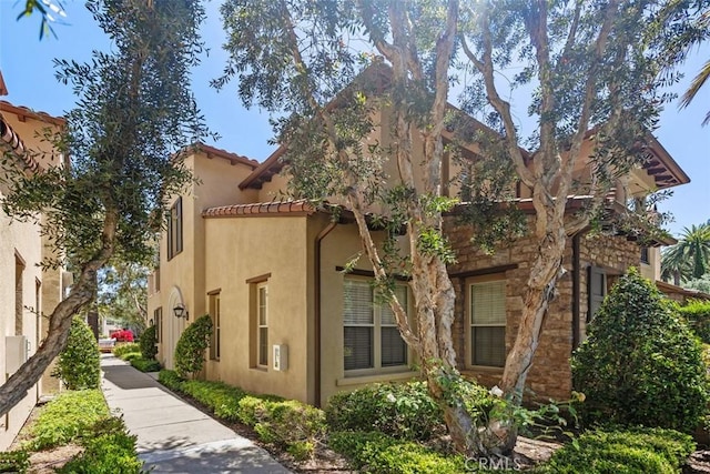 view of home's exterior with a tiled roof and stucco siding