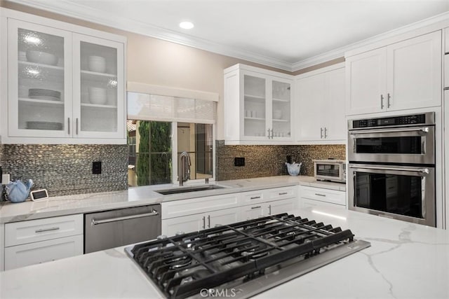 kitchen featuring glass insert cabinets, white cabinetry, and appliances with stainless steel finishes