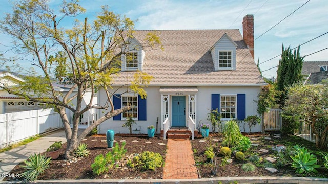 cape cod house with a chimney, stucco siding, a shingled roof, fence private yard, and driveway