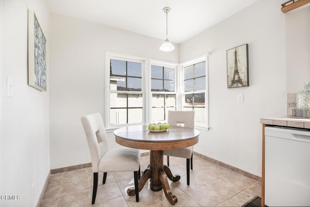 dining area with light tile patterned flooring and baseboards