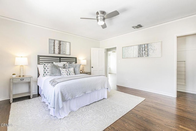 bedroom featuring baseboards, crown molding, visible vents, and wood finished floors