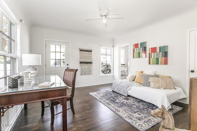 home office featuring baseboards, a ceiling fan, and dark wood-type flooring