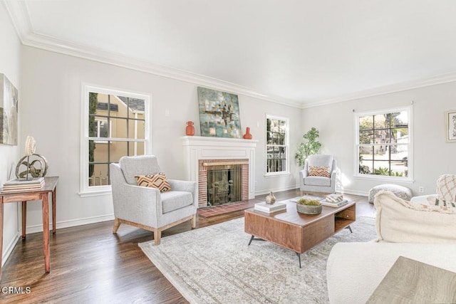 living area with baseboards, dark wood-style flooring, a brick fireplace, and crown molding