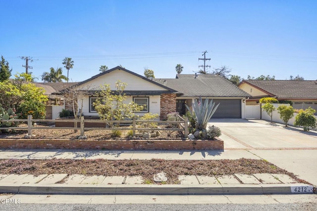 single story home with driveway, a fenced front yard, a garage, and brick siding