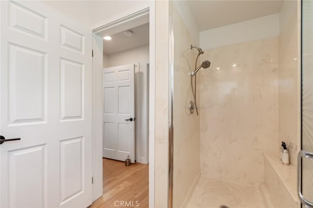 bathroom with a shower stall and wood finished floors