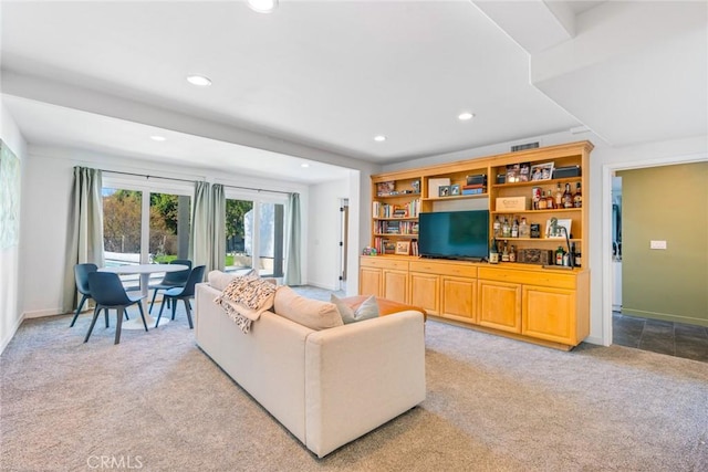 living area featuring recessed lighting, visible vents, baseboards, and light colored carpet