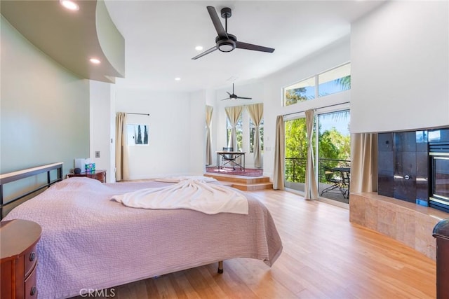 bedroom with recessed lighting, wood finished floors, and access to exterior