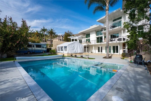 view of swimming pool with a patio area and a pool with connected hot tub