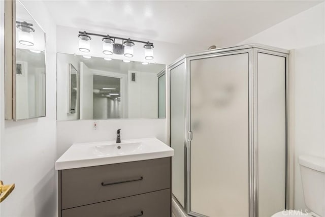 bathroom with visible vents, toilet, a stall shower, and vanity