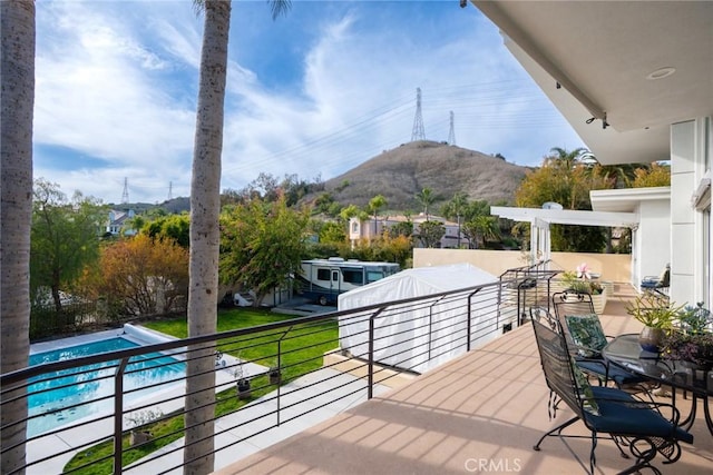 wooden deck featuring an outdoor pool and a mountain view