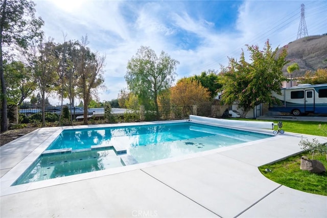 view of pool featuring a pool with connected hot tub and fence