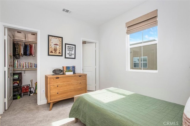 bedroom with carpet, a closet, visible vents, and a walk in closet