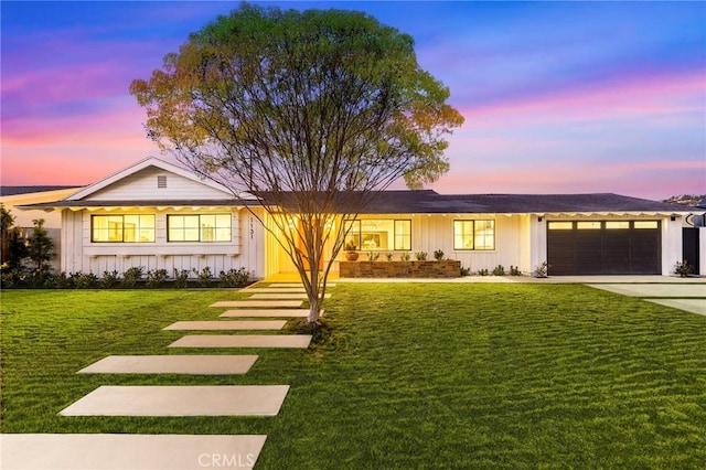 ranch-style house featuring board and batten siding, concrete driveway, an attached garage, and a front lawn