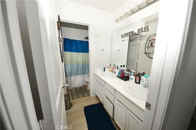 bathroom featuring hardwood / wood-style flooring, vanity, toilet, and a shower with shower curtain