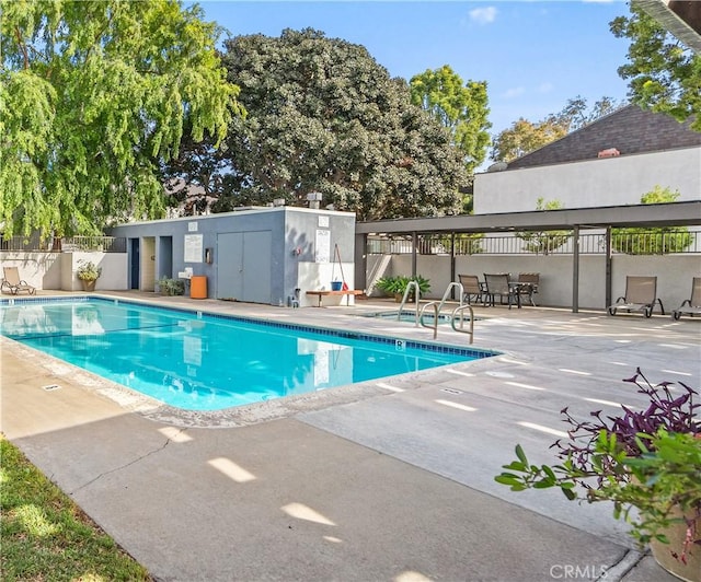 community pool featuring a patio and fence