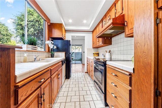 kitchen featuring tile countertops, electric range, tasteful backsplash, and dishwashing machine