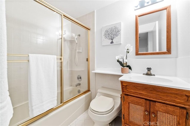 bathroom with tile patterned flooring, shower / bath combination with glass door, vanity, and toilet