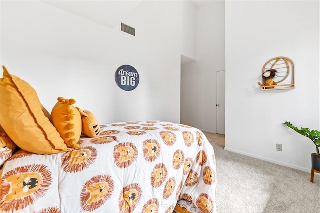 carpeted bedroom with baseboards, visible vents, and a towering ceiling