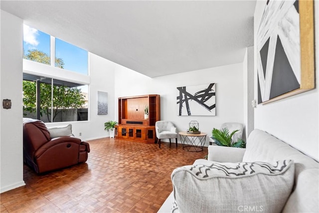 living room featuring baseboards and a towering ceiling