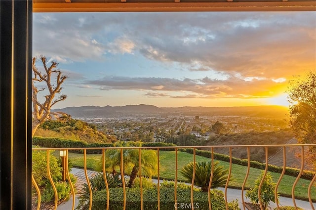 balcony at dusk featuring a mountain view