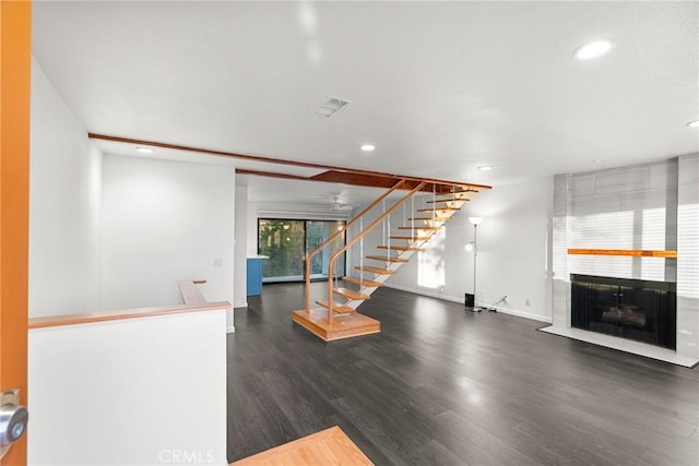 unfurnished living room featuring dark wood-type flooring and a fireplace