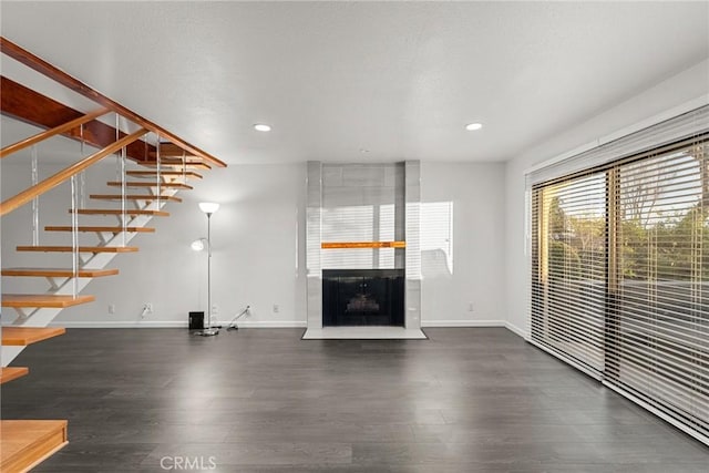 unfurnished living room with dark hardwood / wood-style flooring and a large fireplace