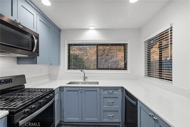 kitchen with sink, blue cabinets, stainless steel appliances, and wine cooler