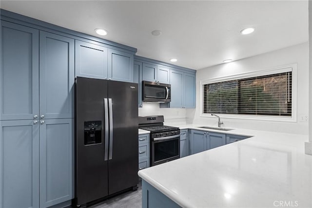 kitchen featuring appliances with stainless steel finishes, sink, and blue cabinetry