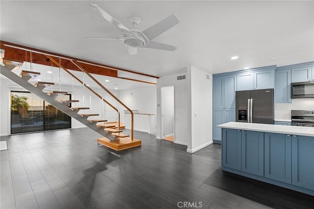 kitchen with dark hardwood / wood-style flooring, ceiling fan, blue cabinets, and stainless steel appliances