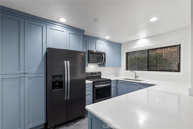 kitchen with blue cabinetry, appliances with stainless steel finishes, and sink