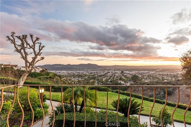 balcony at dusk featuring a mountain view