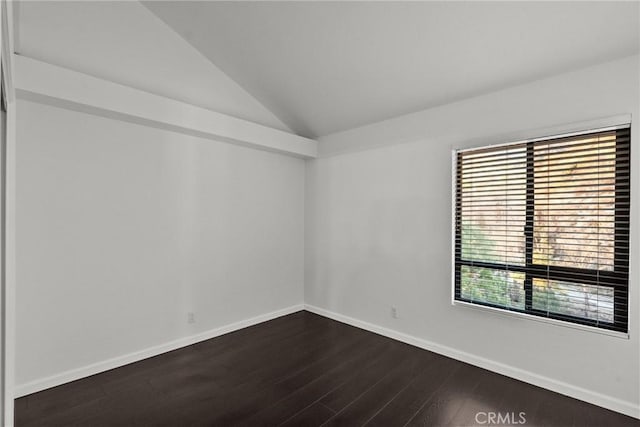 empty room featuring vaulted ceiling and dark hardwood / wood-style flooring