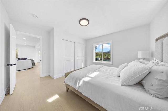 bedroom featuring light wood-type flooring and a closet