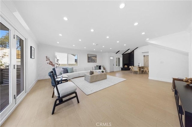 living room featuring light wood-type flooring and vaulted ceiling